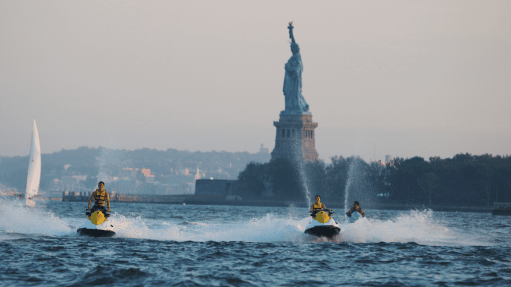 Pessoas andando de Jet Ski com vista da Estátua da Liberdade 